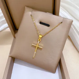 Vue détaillée d'un collier croix de luxe en acier titane doré avec des zircons étincelants