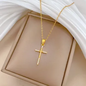 Gros plan détaillé d'un collier croix en acier titane doré avec des strass brillants