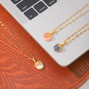 Detail of three cat-eye stone pendant necklaces in pink, blue, and white colors