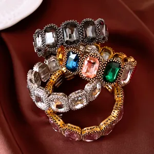 Detailweergave van kleurrijke elastische kristallen armbanden op luxe satijnen stof