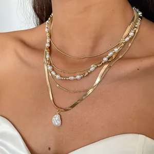 Detailansicht einer goldenen Mehrlagenhalskette mit weißen Perlen und Barock-Anhänger