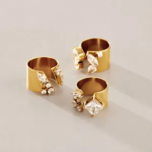 Makroaufnahme goldener Breitringe mit Zirkonia in Marquise- und Prinzessschliff.