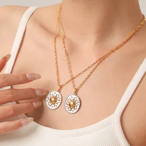 Detailopname van vintage zonneminiatuurhangers aan 18k vergulde kettingen.
