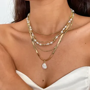 Detailansicht einer goldenen Mehrfachkette im Vintage-Stil mit einem Barockperlenanhänger.