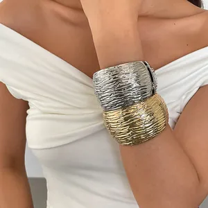 Macro detailopname van de unieke rimpeltextuur op gouden en zilveren metalen armbanden.