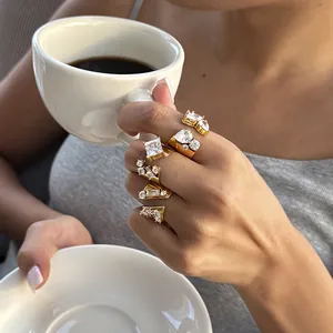 Detailansicht von vergoldeten Edelstahlringen mit funkelnden Zirkonia an einer Hand.