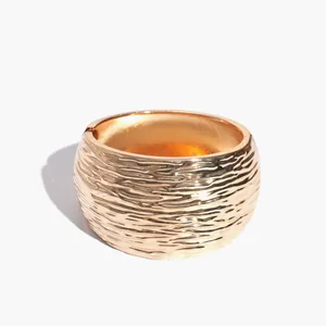 Stijlvolle goudkleurige metalen armband met unieke rimpeltextuur en geometrie.