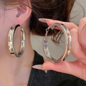 Grandes boucles d'oreilles créoles argentées épaisses avec une finition polie miroir