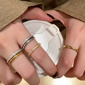 Nahaufnahme von stapelbaren Edelstahlringen mit 18 Karat Goldbeschichtung und Zirkonsteinen