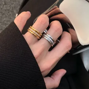 Nahaufnahme von 18K vergoldeten und silbernen Edelstahlringen mit Zirkonia am Finger.