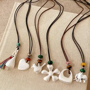 Collane boho in cordino con ciondoli argento cuore, uccello, fiore e perle in ceramica.