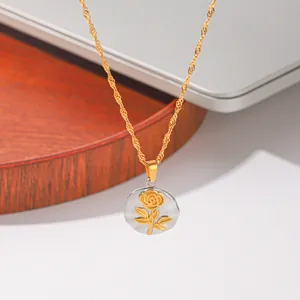 Detail van een ronde zilveren hanger met een gouden reliëfroos en gouden ketting