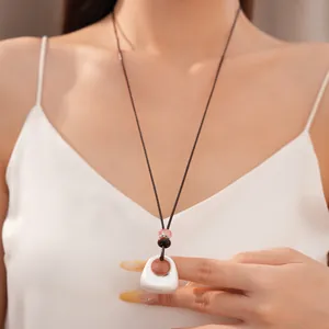 Elegante collana lunga in pelle con perline rosa e ciondolo quadrato argento su modella