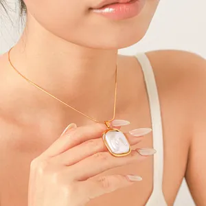 Vue détaillée d'un collier en or avec un pendentif en perle baroque porté par un mannequin