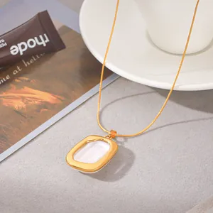 Gros plan d'un collier doré élégant avec un pendentif en perle baroque blanche raffinée.
