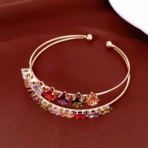 Vista dettagliata di un bracciale rigido placcato oro 18k con zirconi a rombo colorati