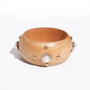 Retro etnische houten armband met metalen klinknagels en parels op witte achtergrond.