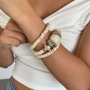 Detailopname van een vintage etnische houten armband met zilveren klinknagelkralen om pols