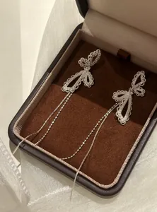 Exquisite silberne Schleifenohrringe mit glitzernden Diamanten und langen Quasten