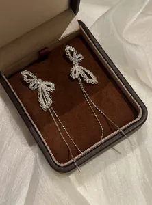 Detail von eleganten silbernen Schmetterling-Ohrringen in einer braunen Geschenkbox.