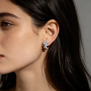 Vue rapprochée de boucles d'oreilles ange minimalistes en acier avec petit diamant