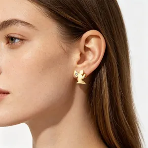 Gros plan d'une boucle d'oreille ange en or avec strass brillant portée par un mannequin