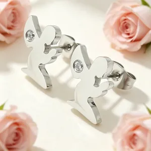 Détail de boucles d'oreilles ange en acier inoxydable avec cristaux et roses roses.