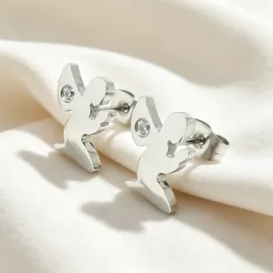 Gros plan de boucles d'oreilles ange en argent avec cristal sur tissu blanc