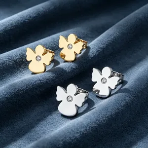 Détail de boucles d'oreilles ange en or et argent avec strass central brillant