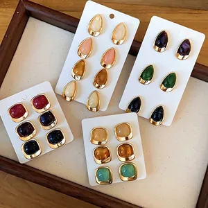 Set of vintage-style acrylic earrings in teardrop and square shapes with gold frames.
