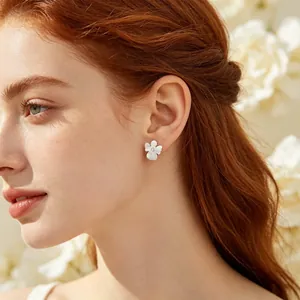 Détail en gros plan d'une boucle d'oreille fleur en argent mat avec un diamant étincelant