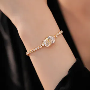 Vista ravvicinata di un bracciale placcato oro con zircone quadrato e farfalla dorata.
