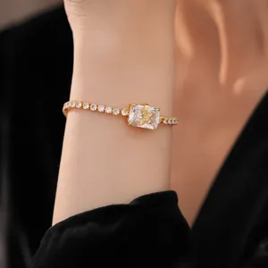Dettaglio di un bracciale di lusso con farfalla e zircone quadrato placcato oro al polso