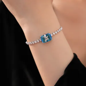 Dettaglio del bracciale tennis placcato oro con zircone blu e motivo a farfalla