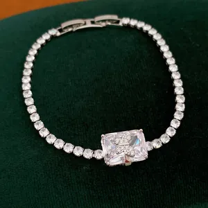 Primo piano di un elegante bracciale in zircone con farfalla su velluto verde scuro.