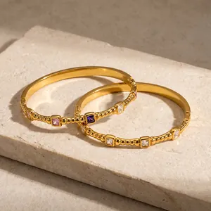 Detailansicht goldener Edelstahl-Armreifen mit farbenfrohen quadratischen Zirkonia-Steinen