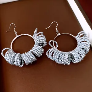 Close-up of vintage style silver beaded hoop earrings with intricate fringe detail