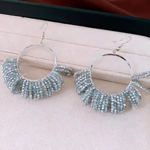 Close-up of vintage beaded hoop earrings with silver hooks presented in a jewelry box