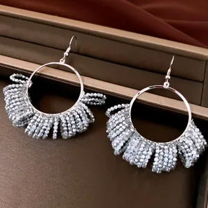 Detailed view of silver-tone hoop earrings with intricate grey beaded fringe