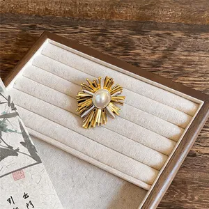 Eleganter 18 Karat vergoldeter Sonnenstrahl-Brosche mit Perle auf einem Display-Tablett