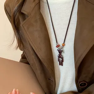 Detailansicht einer Pulloverkette mit Bären- und Schmetterlingsanhänger auf Jacke