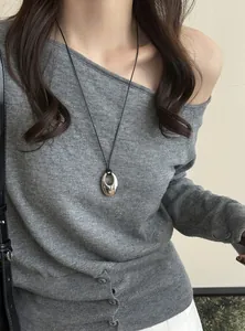 Nahaufnahme eines koreanischen ovalen Silberanhängers an einer schwarzen Lederschnur für Damen.