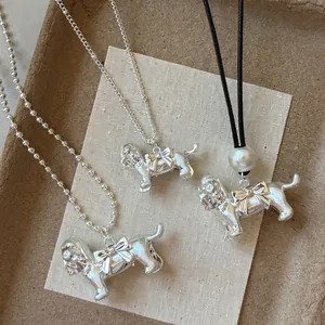 Vue détaillée de pendentifs chiots argentés avec nœuds et chaînes à billes
