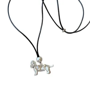 Collier en cordon noir minimaliste avec un pendentif chiot argenté et un nœud papillon