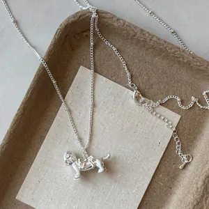 Gros plan d'un collier avec pendentif chiot argenté et un nœud papillon délicat