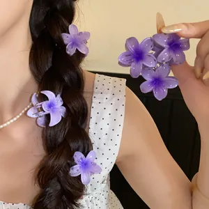 Gros plan de mini pinces à cheveux en forme de fleurs violettes dans une tresse élégante
