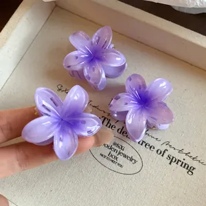 Vue détaillée de mini pinces à cheveux fleurs en acrylique violet sur un plateau