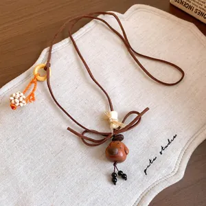 Detailed view of a vintage wooden dog pendant necklace with cute cord bow accents