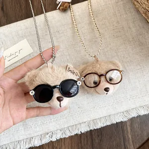Detailansicht süßer Plüschbär-Anhänger mit Brille an Kugel- und Gliederketten.