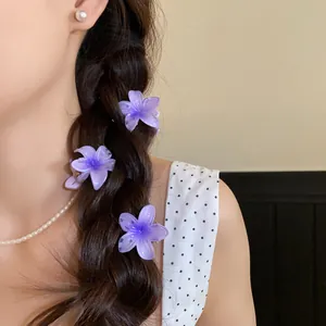 Gros plan de mini pinces à cheveux fleurs en acrylique violettes dans une tresse douce